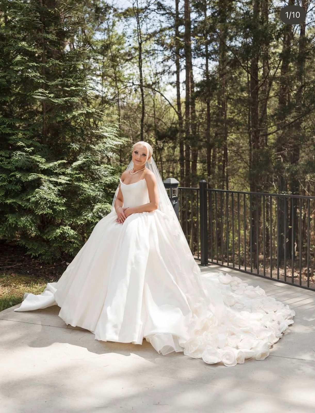 Bride in a strapless ball gown on a terrace among pine trees