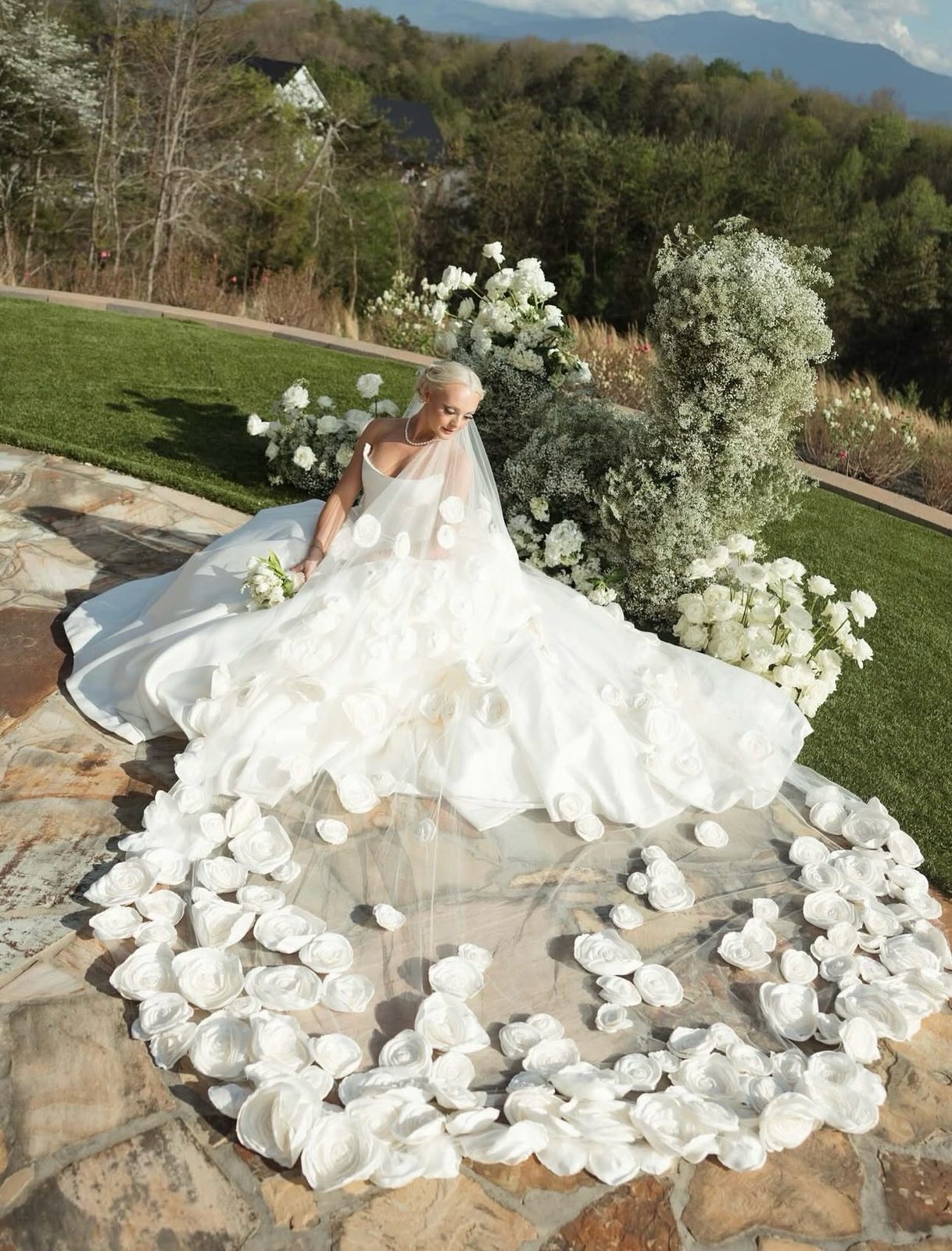 Bride with a long cathedral train circled by white petals